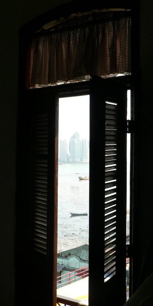 Open window with view of Panama City skyline and boats in the bay.