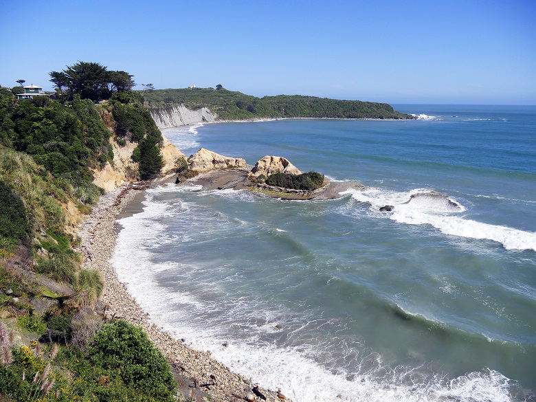 sea waves crashing into vegetated cliffs