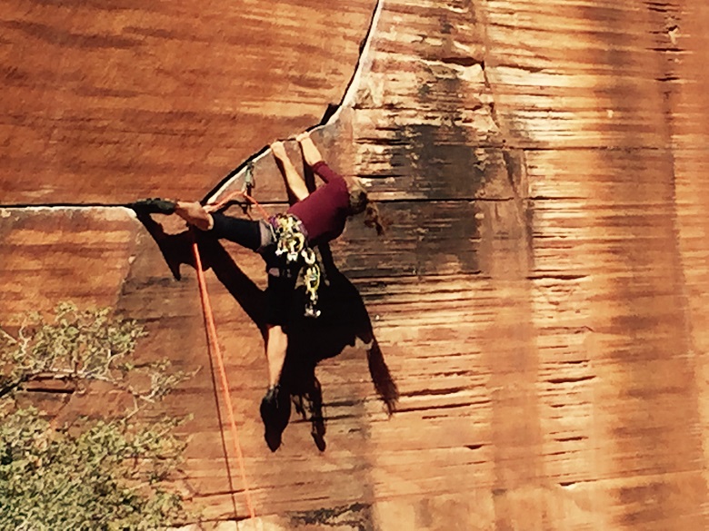 woman climbing crack in red sandstone