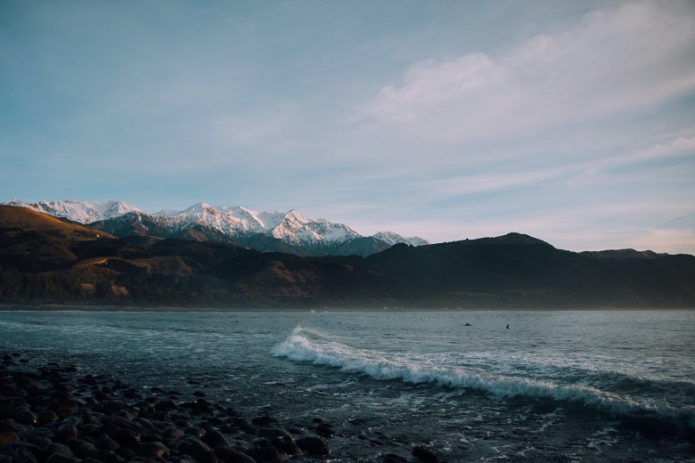 sea waves with snowy mountains in the background