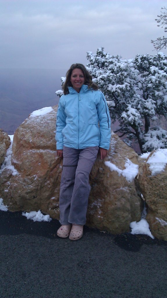 smiling girl in blue winter jacket and pink crocs