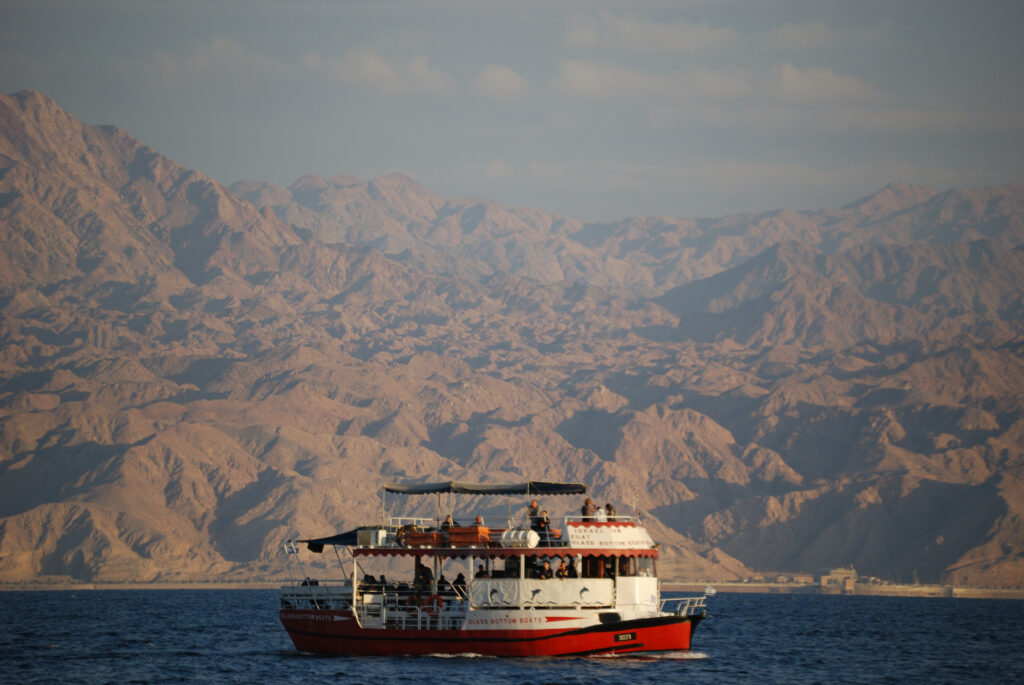 boat on sea with mountains in background